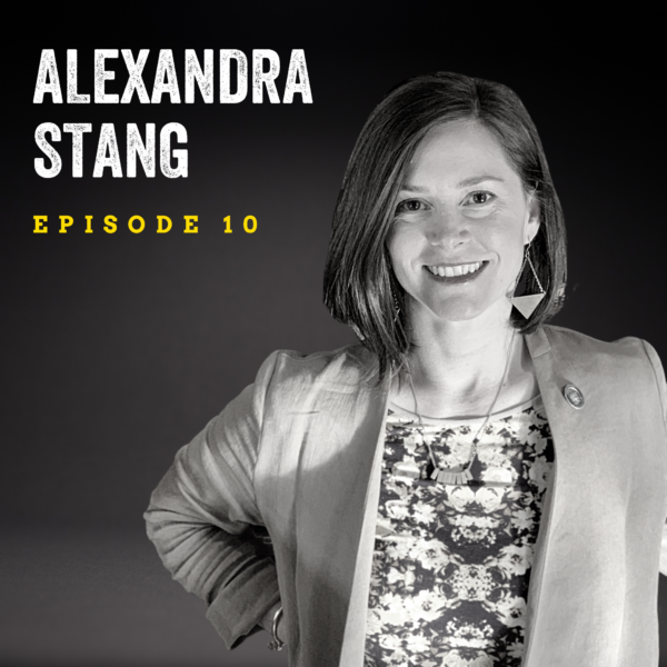 Black and white image of woman standing with hands on her hips, wearing a light suit jacket and floral shirt. The background is dark and a text overlay reads "Alexander Stang Episode 10."