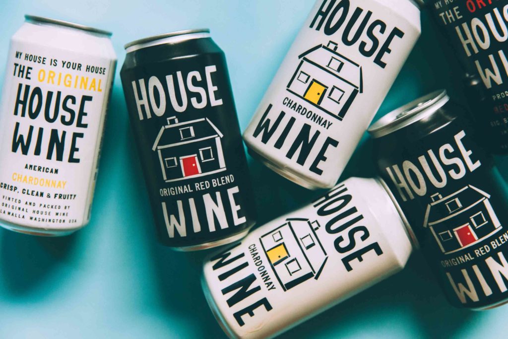 Six cans of wine with House Wine labels, three are white labels and three are black labels. 